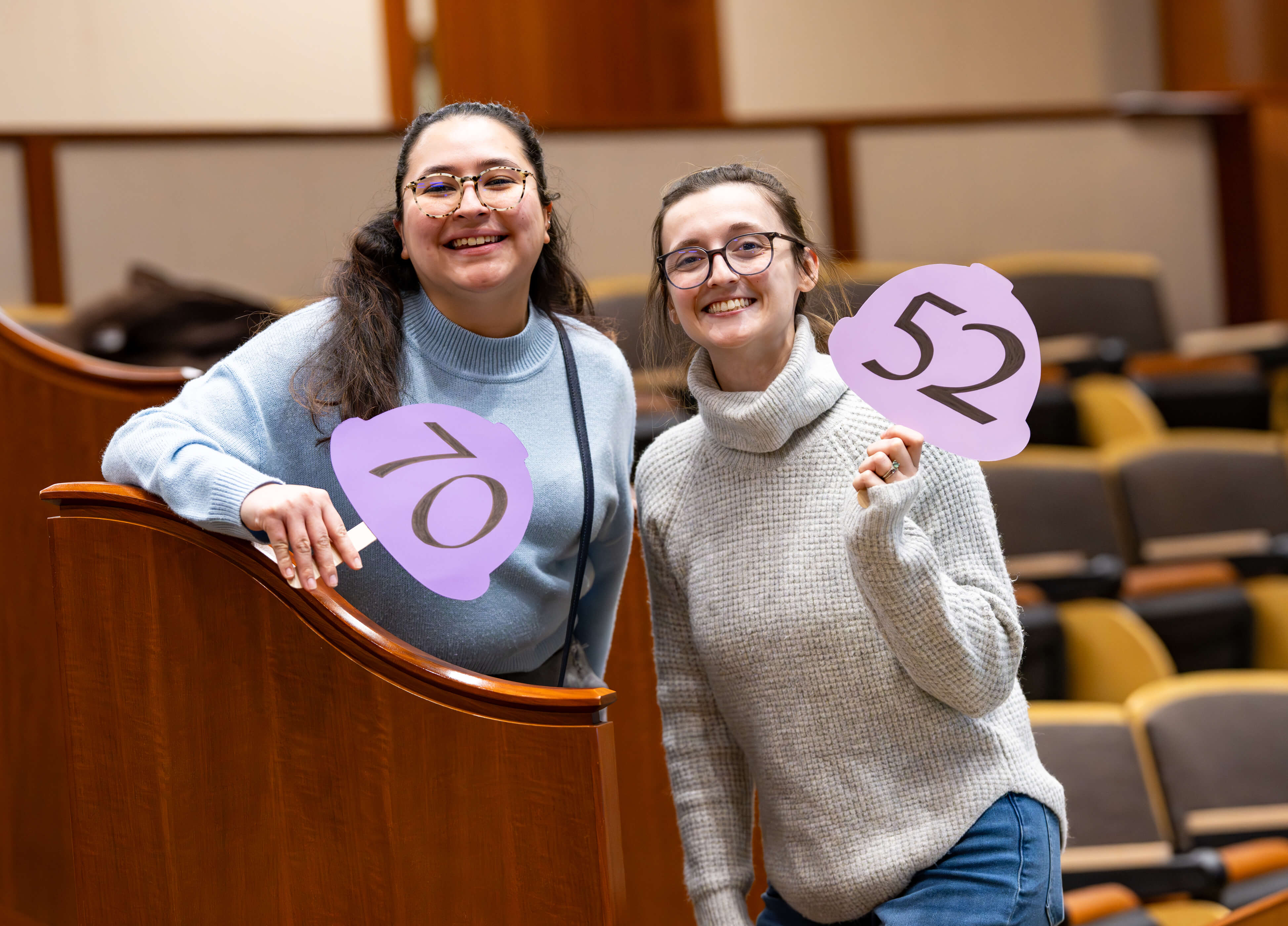 Two individuals hold up numbers at the PILP Auction