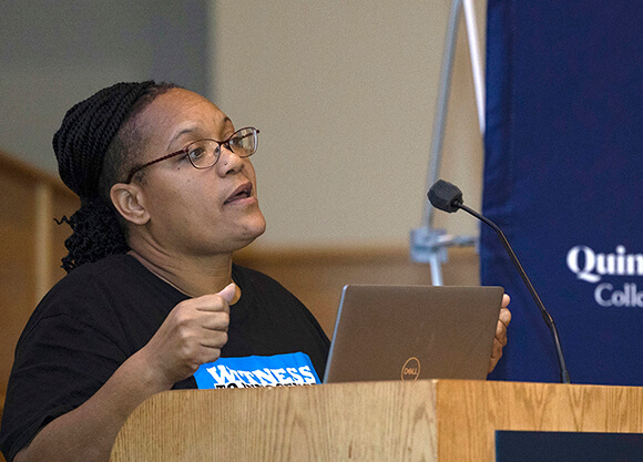 Sabrina Butler-Smith speaks from a podium in the Mount Carmel Auditorium