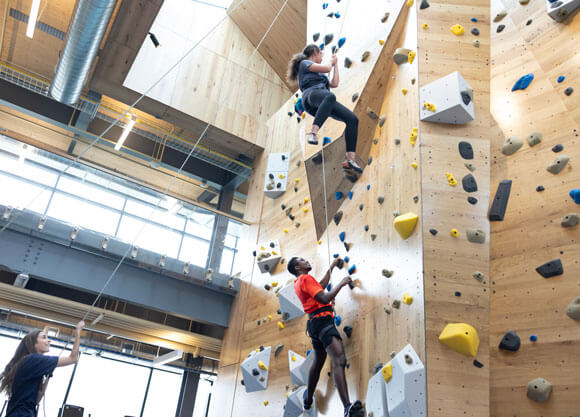 Students climbing new rock wall in the Recreation and Wellness Center