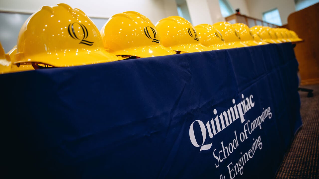 Hard hats are lined up on a table.