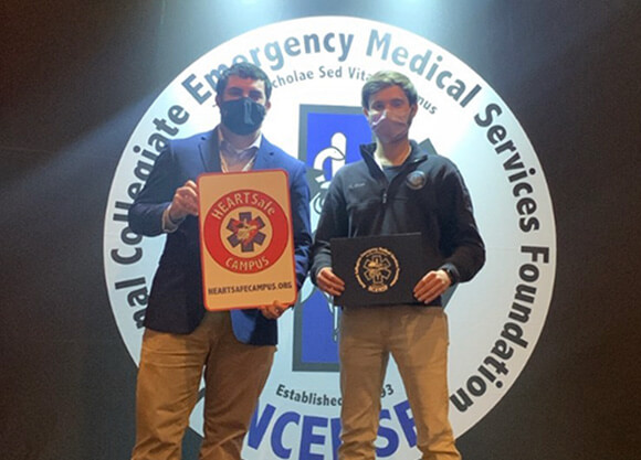 QU EMS members Alex Bayer and Charles Dunn with HEARTSafe Campus sign