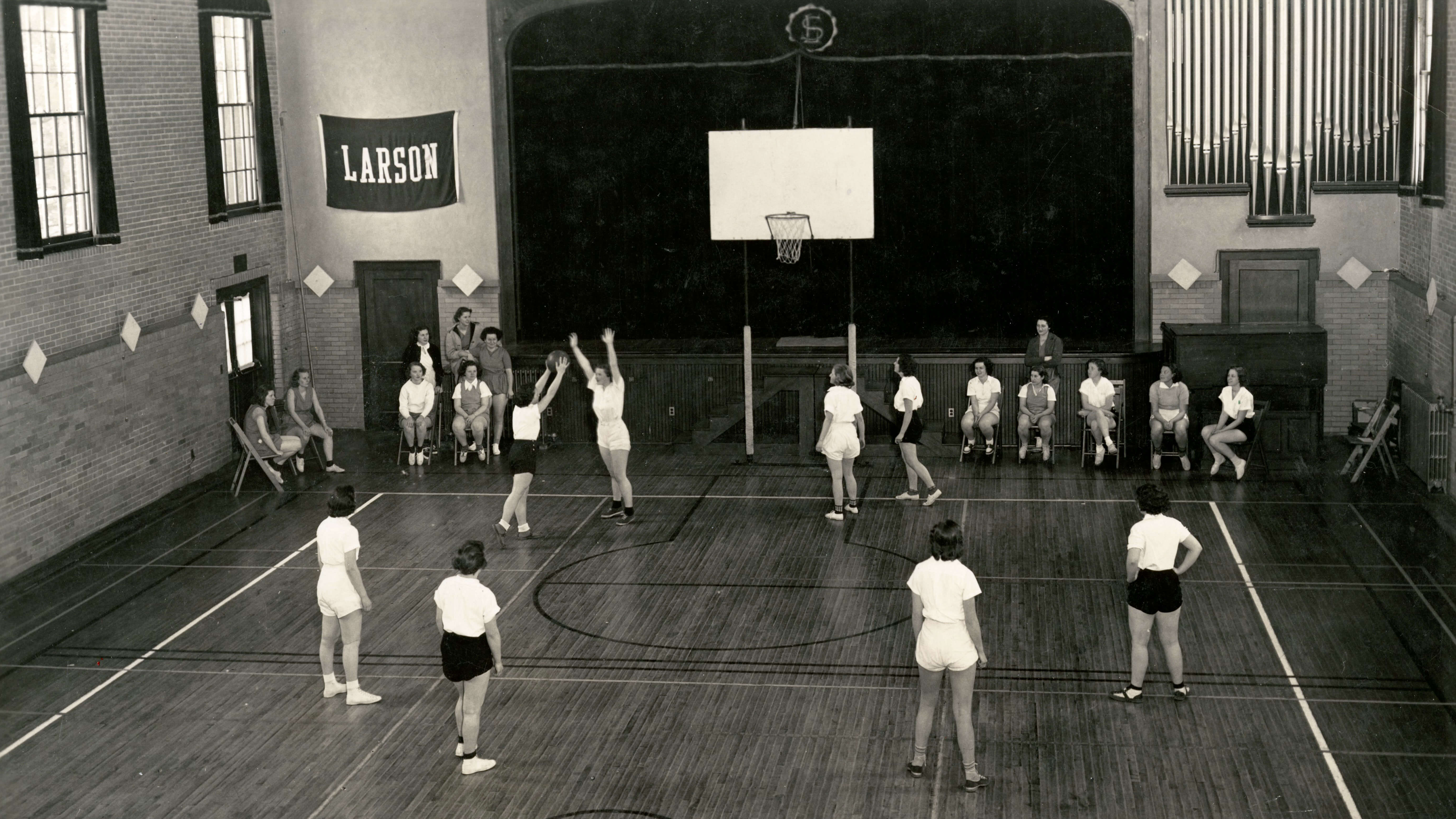 Ladies playing basketball on an indoor court