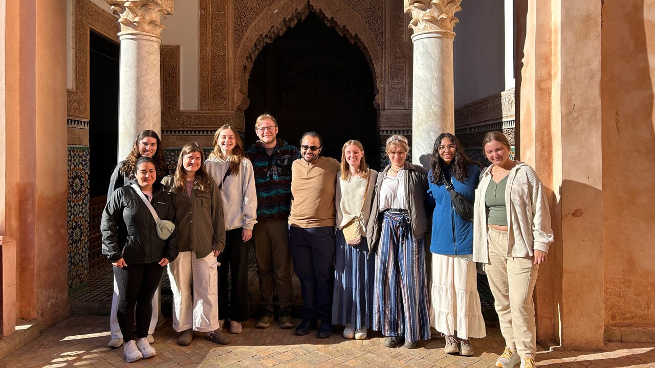 A group of 10 students stands in front of the Metropolitan Museum of Art’s Moroccan Court.