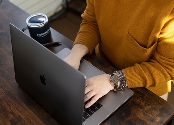 Photo of a woman typing on a computer