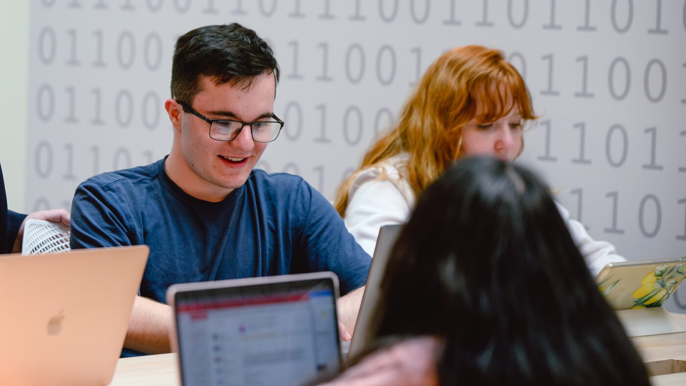 a group of students working on laptop at a table