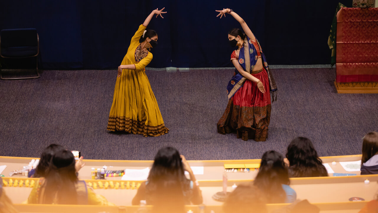 Two students in traditional costumes dance during a Bollywood festival
