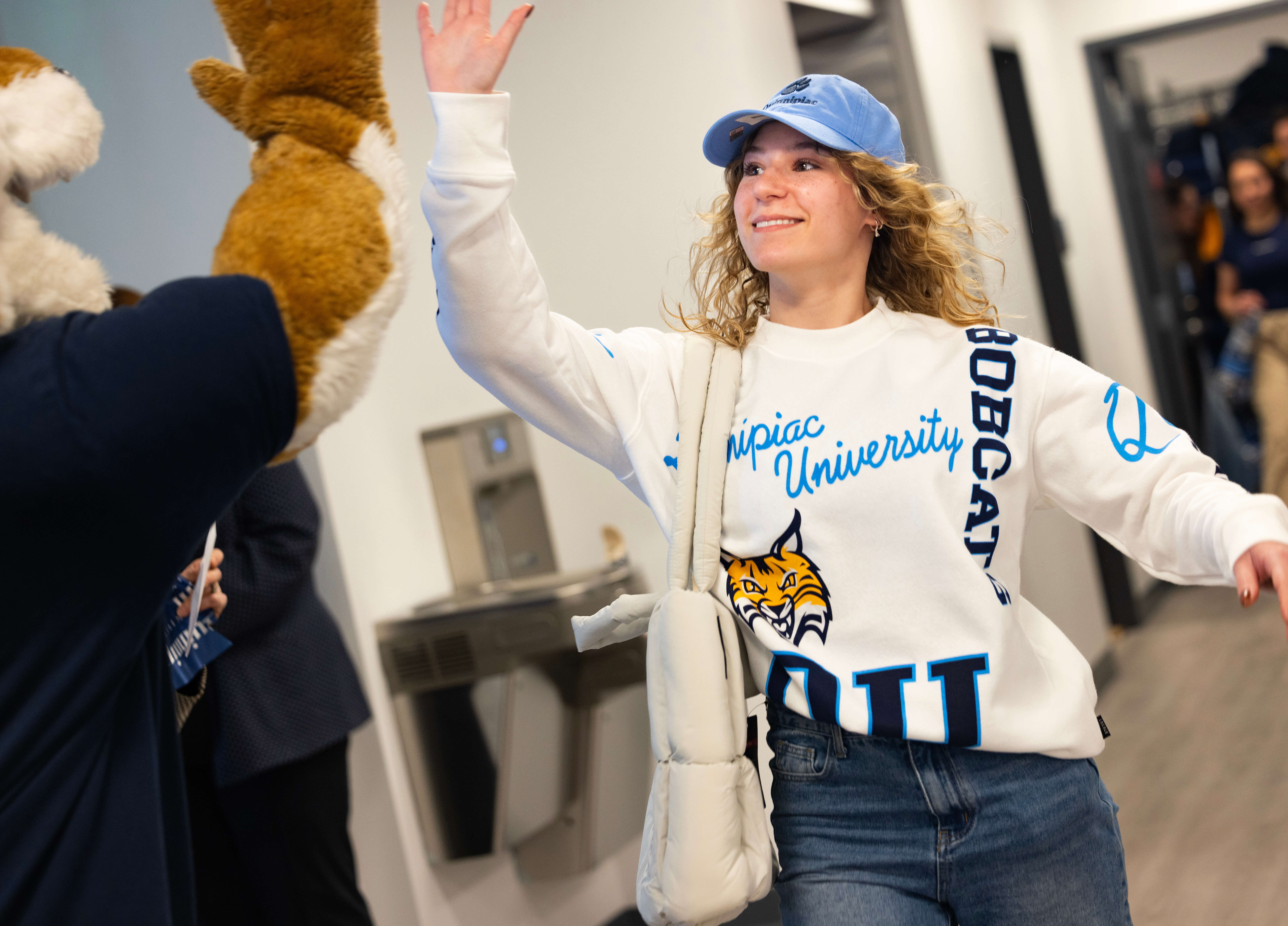 Student greets Boomer at Quinnipiac's bookstore ribbon cutting