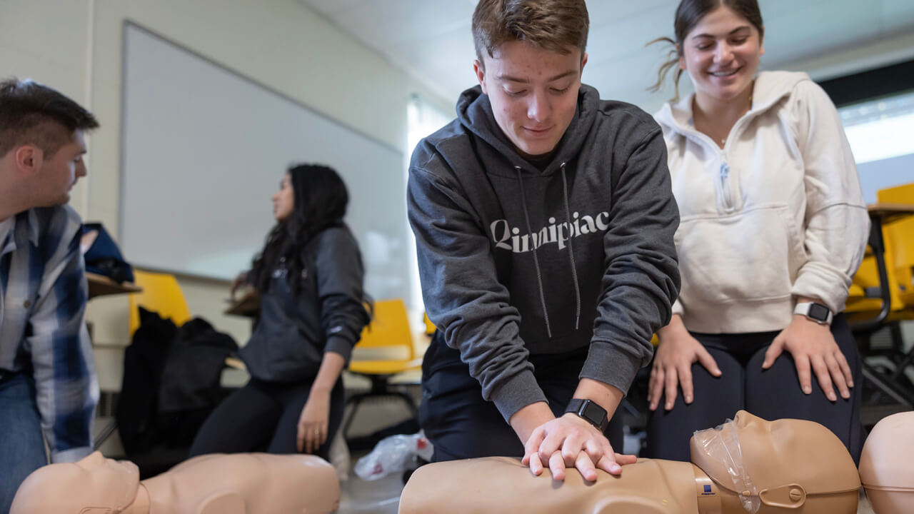 Students perform compressions on a mannequin.