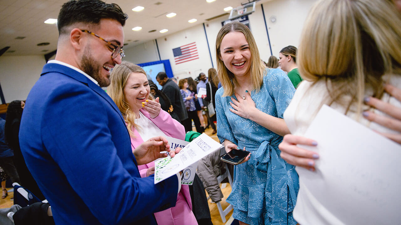 Medical school students speak with each other after finding out their matches.