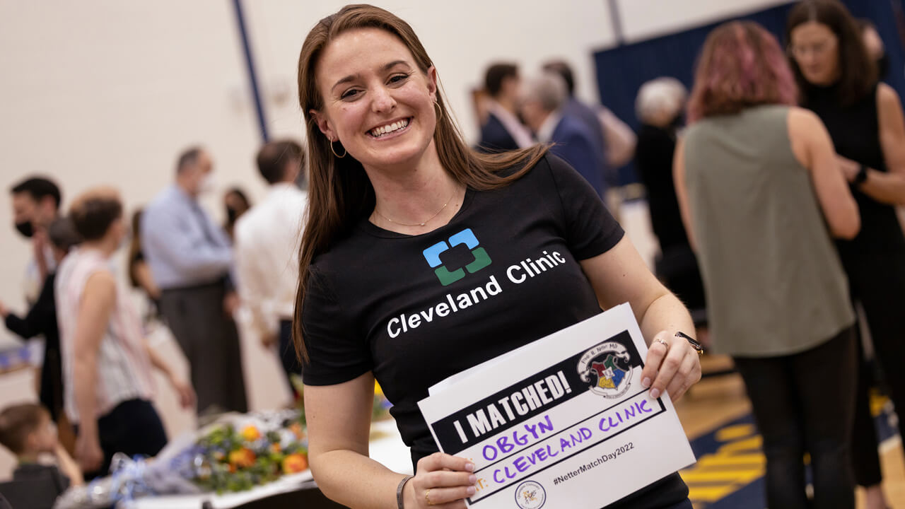 Jennifer Hansen holds up a sign indicating her match in OB/GYN with Cleveland Clinic