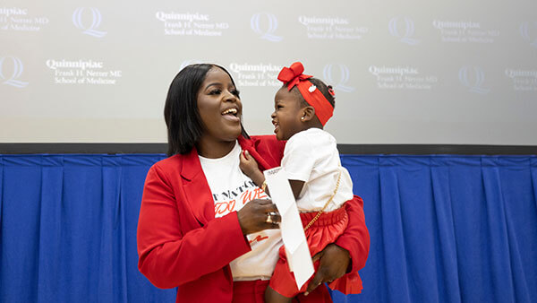 Caurice Wynter, MD ’22, holds her baby daughter at Match Day.