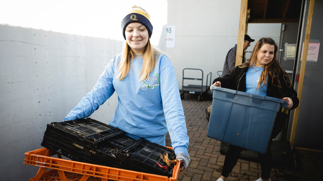 Francesca Link, Health Sciences ‘21 from the Tri-Delta Soririty (left) and Gabby Russitano, Psychology, ’23, also Tri-Delta (right), as well as other Quinnipiac students, carrying bins while helping at Master’s Manna, a Food Bank and cooperative in Wallingford, CT, to organize and clean up the workspaces.