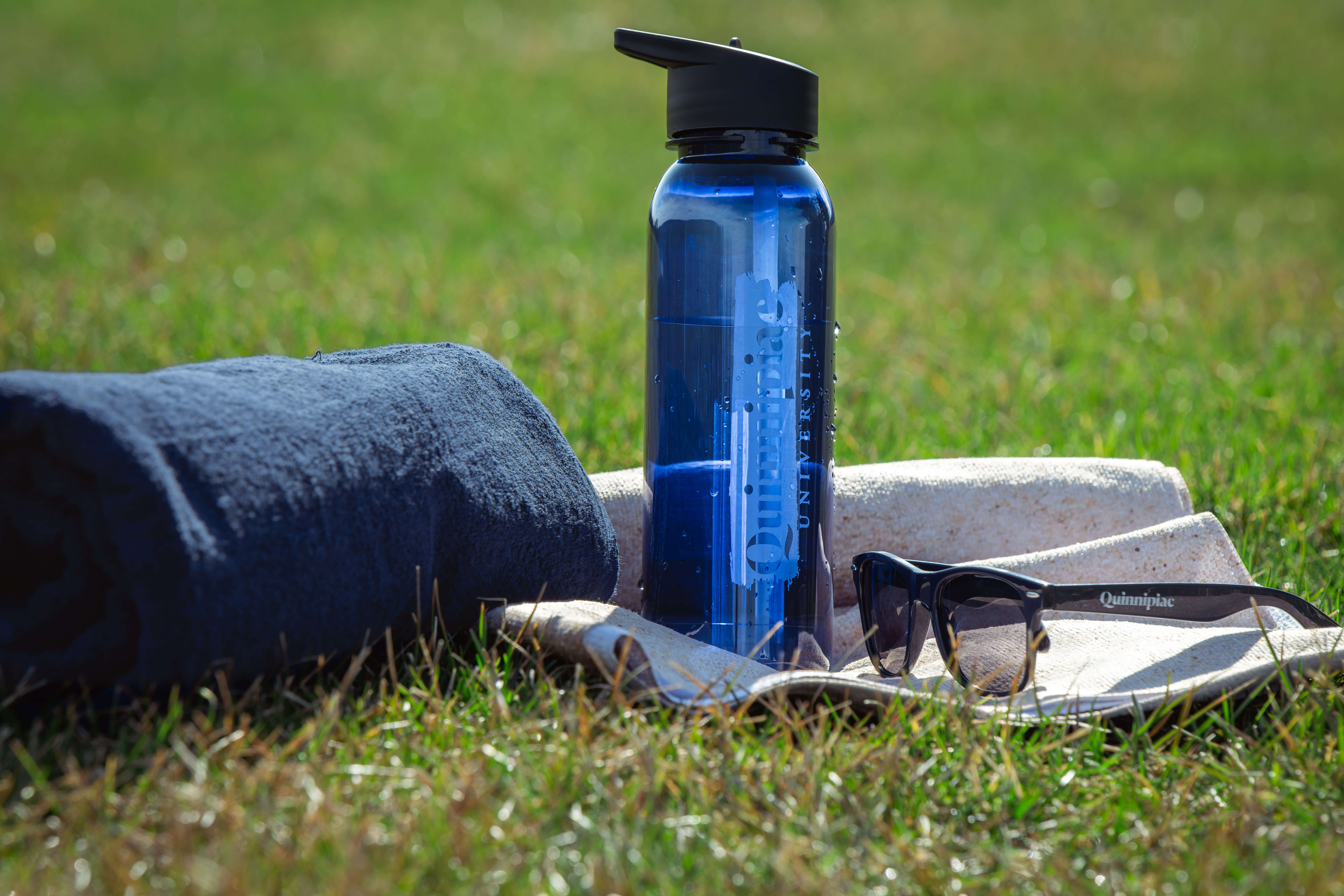 A towel, water bottle and sunglasses on the Quad