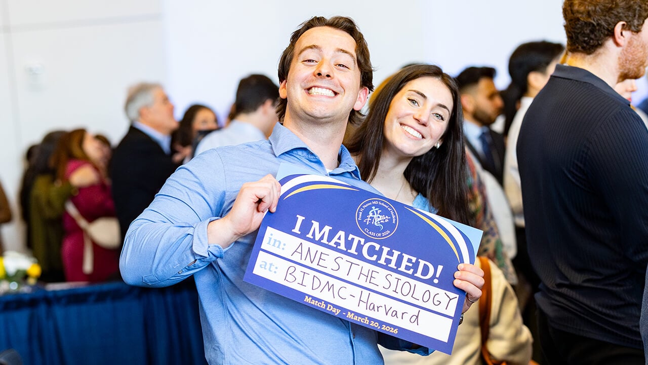 Student posing with her match sign on Match Day 2026