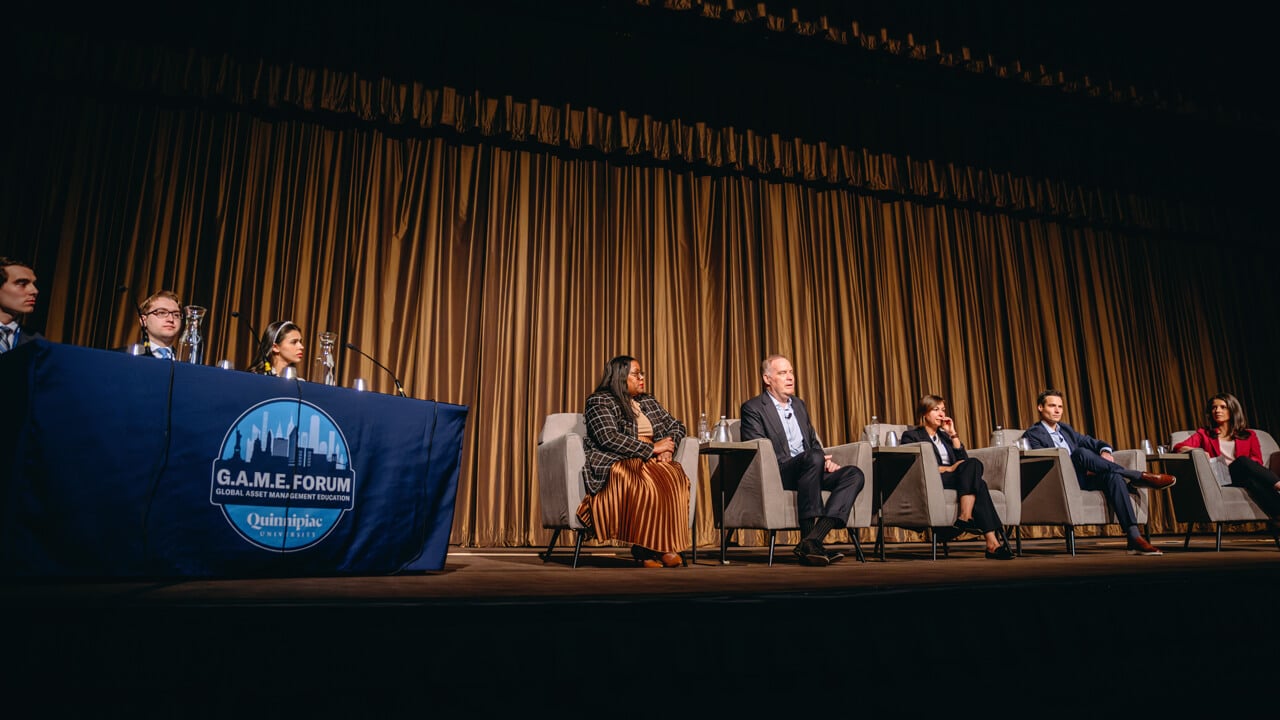 Students and professionals sit on stage in a panel discussion during Quinnipiac GAME Forum