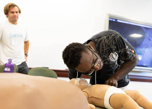 Student performing CPR on a mannequin