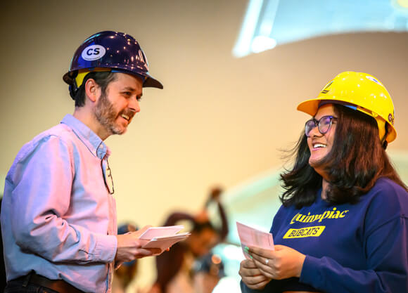 Computing faculty congratulates a computing student at the hard hat ceremony.
