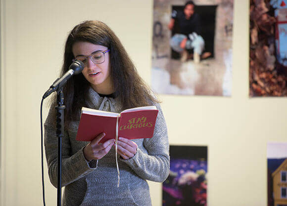 Student participating in a poetry open mic night