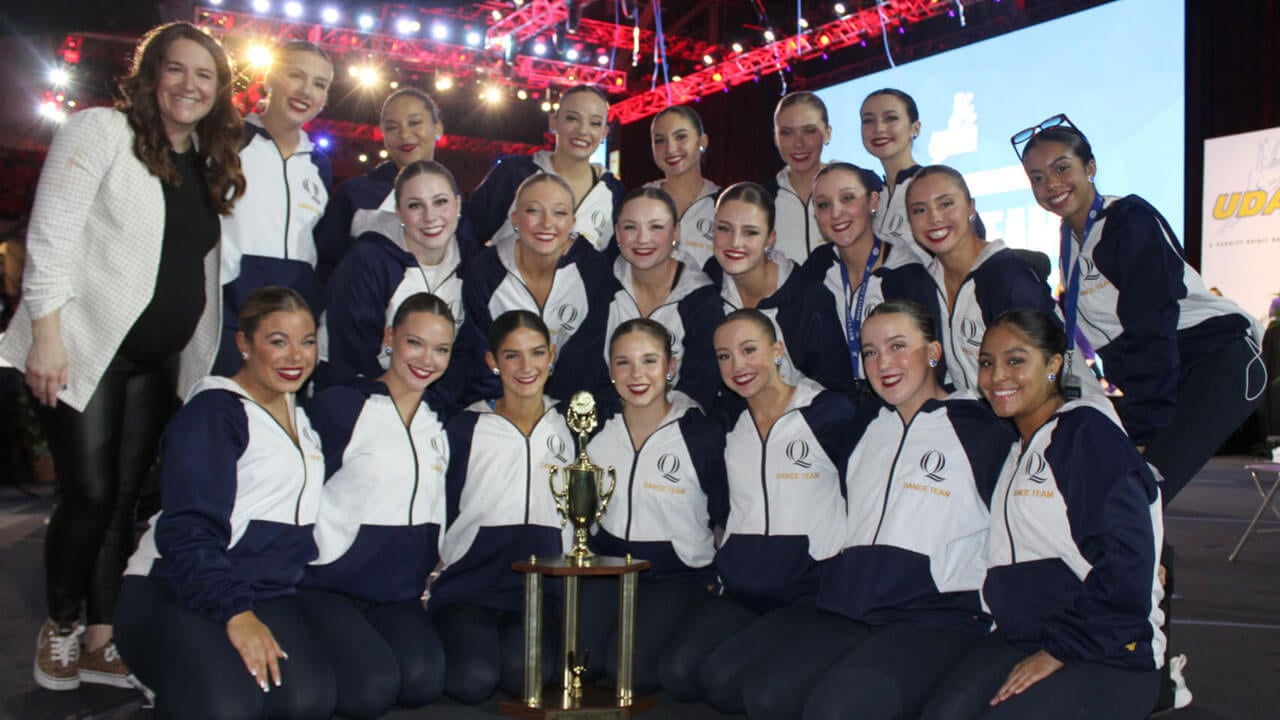 Dance team posing with competition trophy