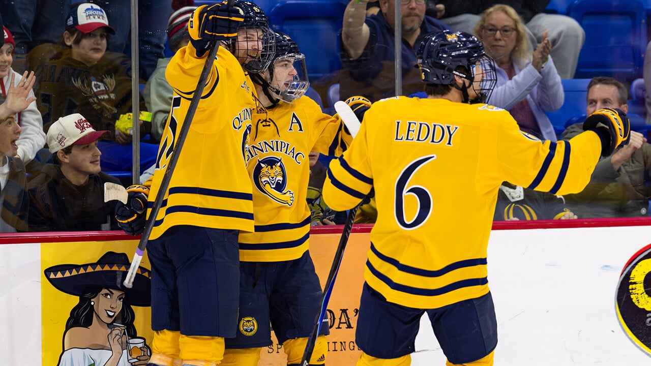 Quinnipiac's men's ice hockey team celebrates a goal.