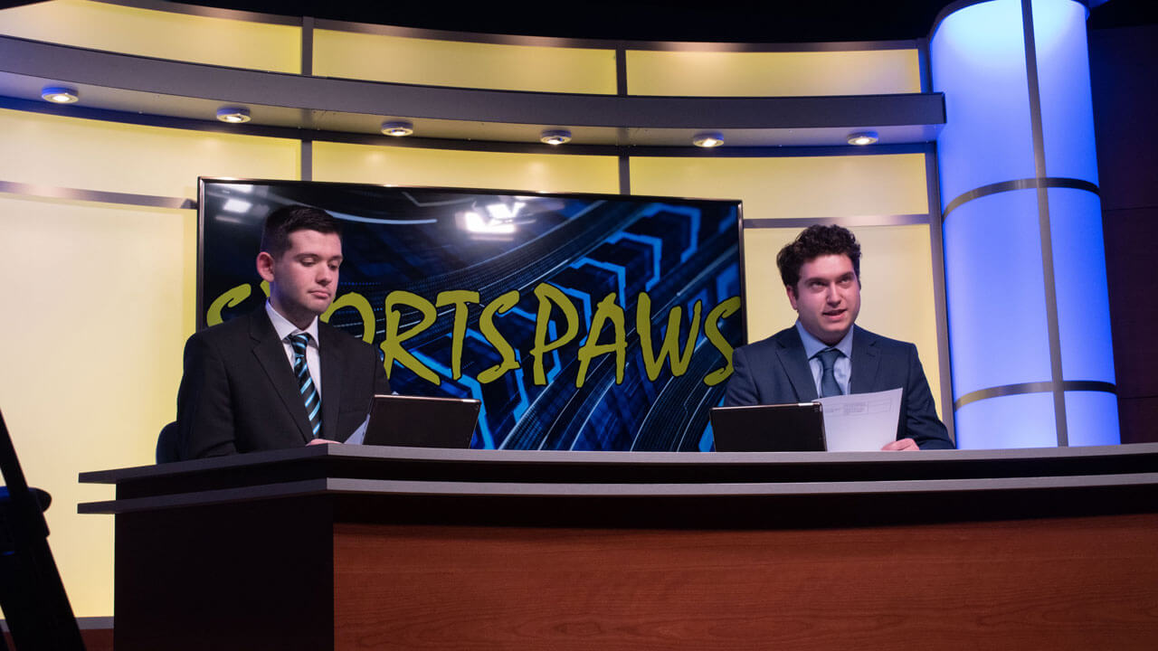Clever Streich and Joey O'Donoghue live on desk in the new Q30TV studio for sports paws