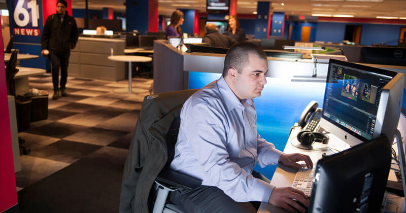 Giovanni in the FOX News office typing on a computer