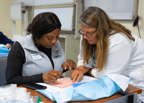 nurse practicing skills alongside instructor