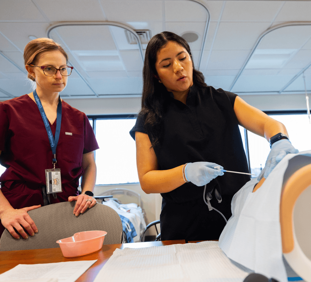 nursing student practicing skills with instructor in simulation lab