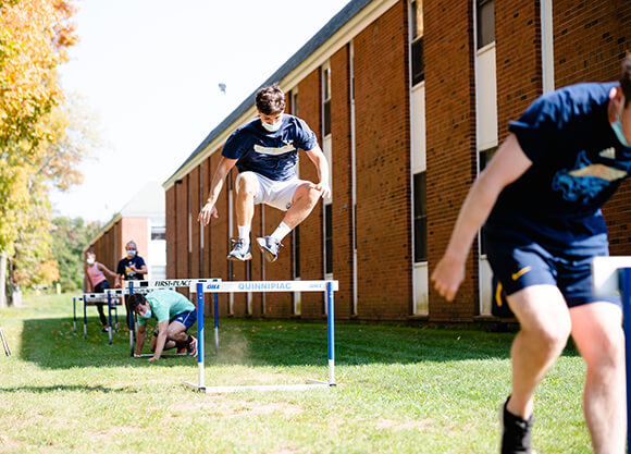 Students jump over an obstacle