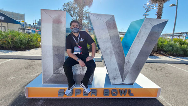Ahearn sits on a Super Bowl sign