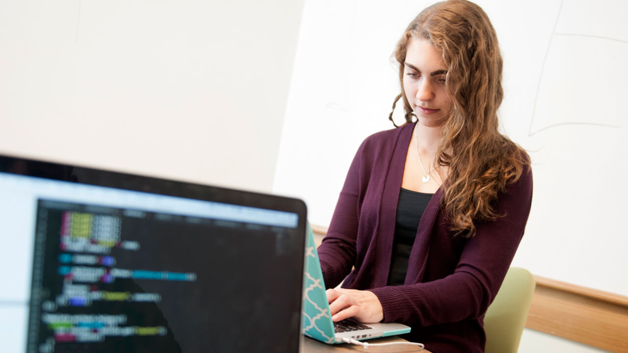 Quinnipiac student Janine Jay, a software engineering major and math minor, competes in the bi-annual hackathon on her laptop.