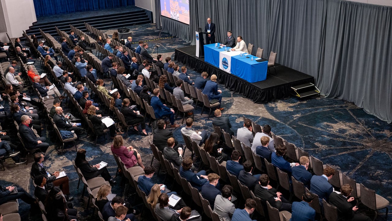 A room full of people listen to the panelists.