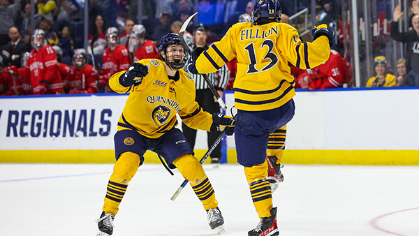 Two Quinnipiac hockey players celebrate on the ice at the NCAA Tournament Regional in Bridgeport, CT.