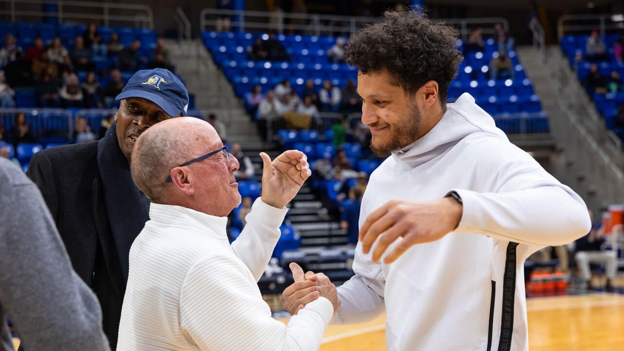 Quinnipiac mens basketball player giving a guy a handshake