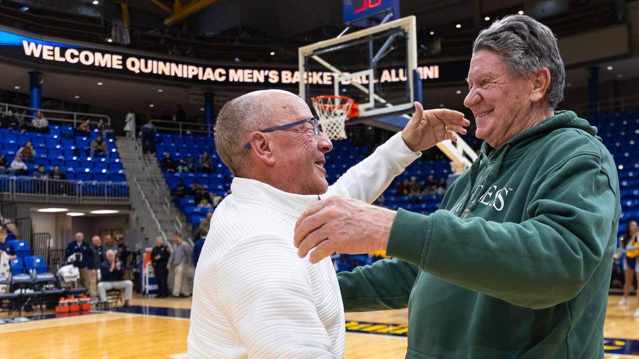 Two men meet at center court for a handshake in M&T Bank Arena