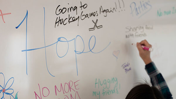 Student writes messages of hope on marker board