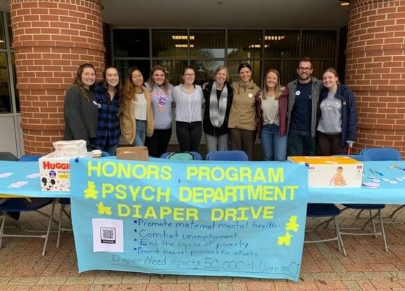 students and faculty behind diaper drive table