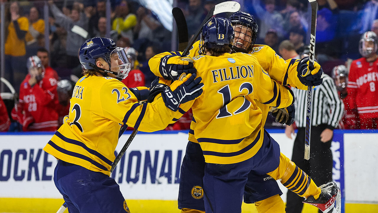 Men's Ice Hockey players cheer after another goal against Ohio State