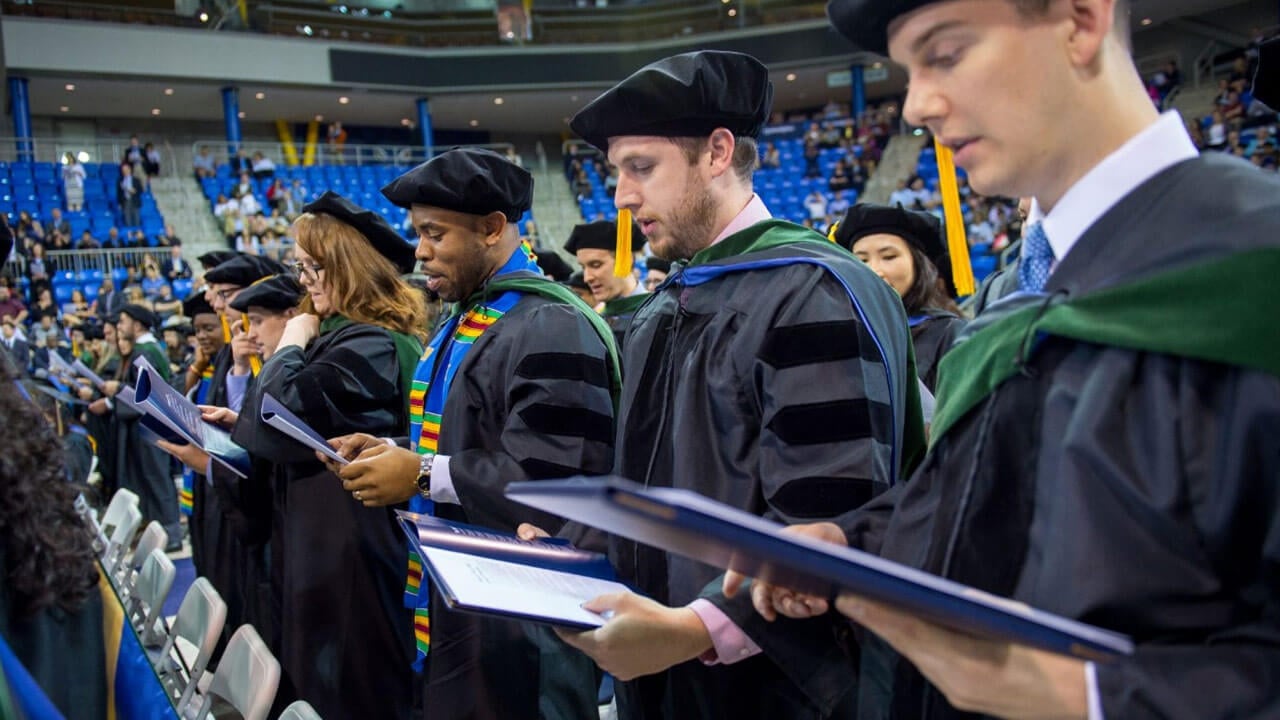 Medical students stand during a commencement ceremony