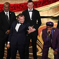 Dave Rabinowitz stands onstage at the Oscars with director Spike Lee