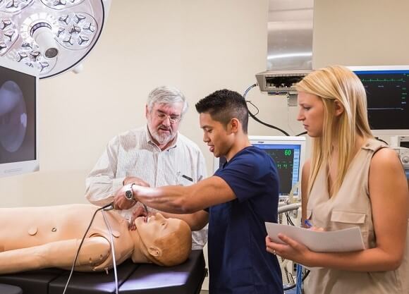 Medical students examine a simulated patient