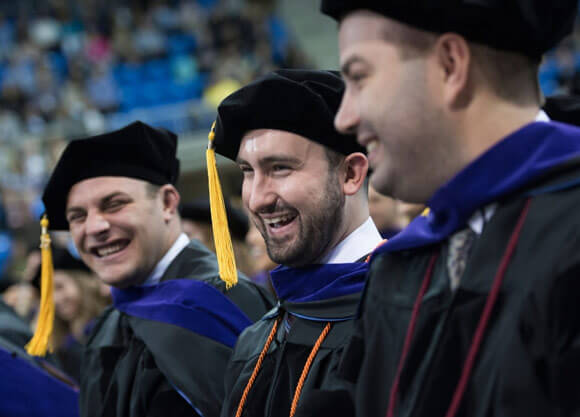 Graduates laughing and smiling at the School of Law graduation