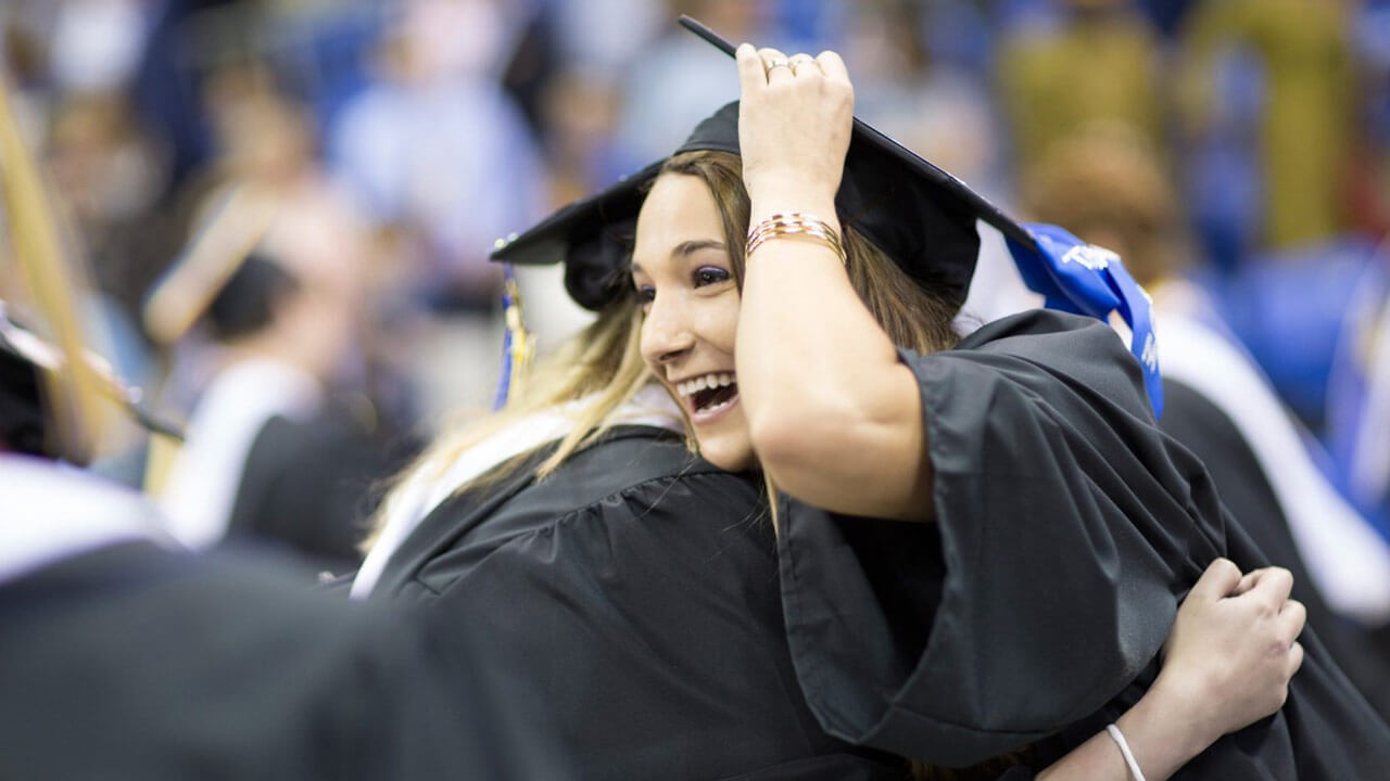 Two students hugging at commencement