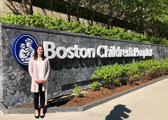Photo of Marisa Otis standing in front of Boston Children's Hospital