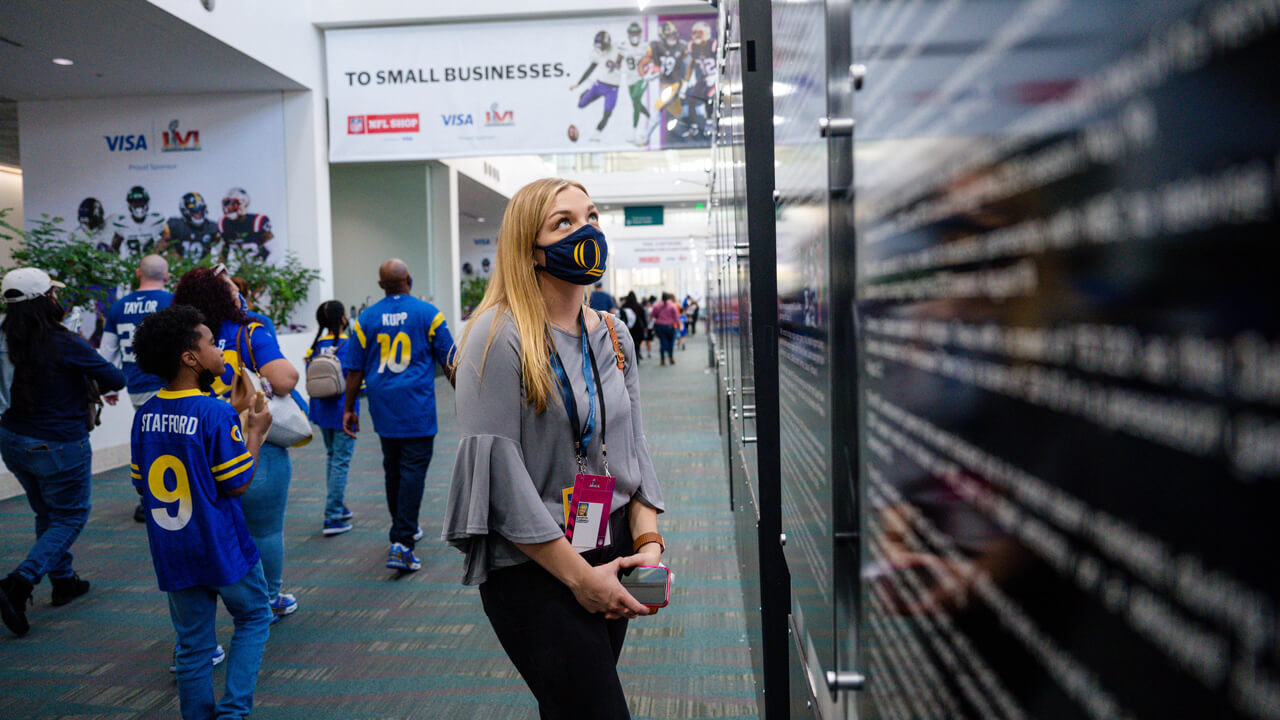A female student looks at a football exhibit