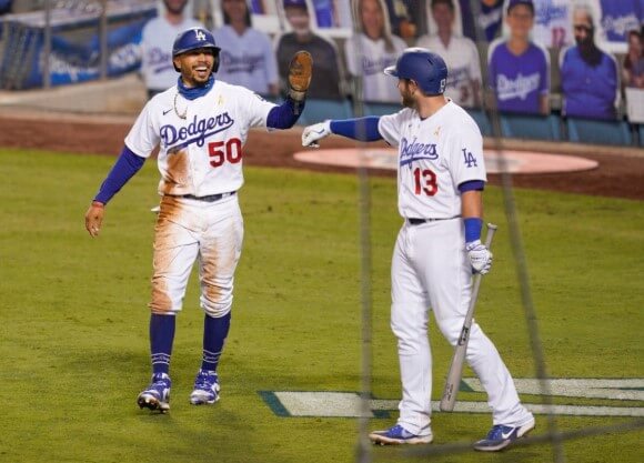 Two Dodgers players high five during a game