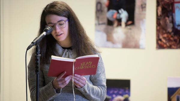 Student reads in front of a microphone