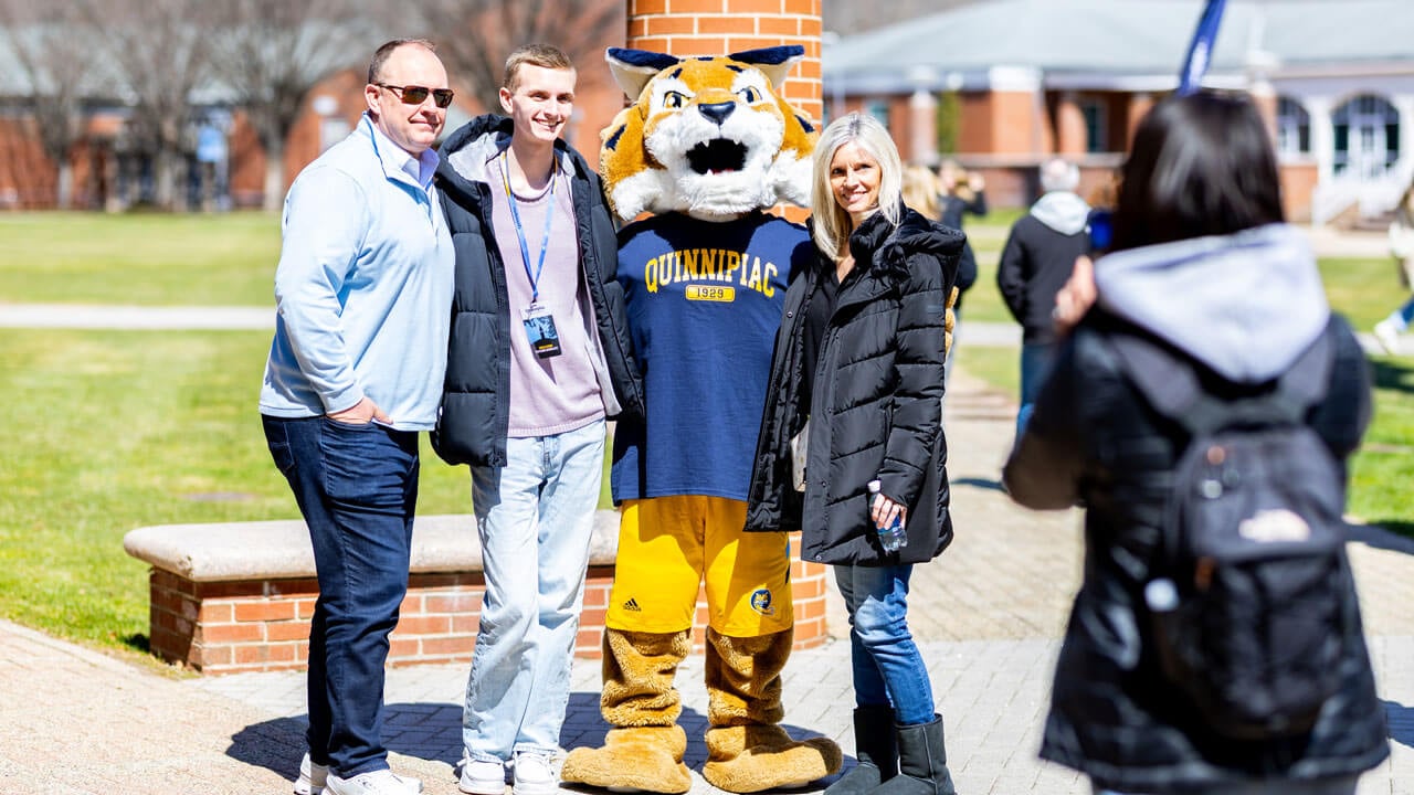 Families pose with boomer on the quad during the admitted students event