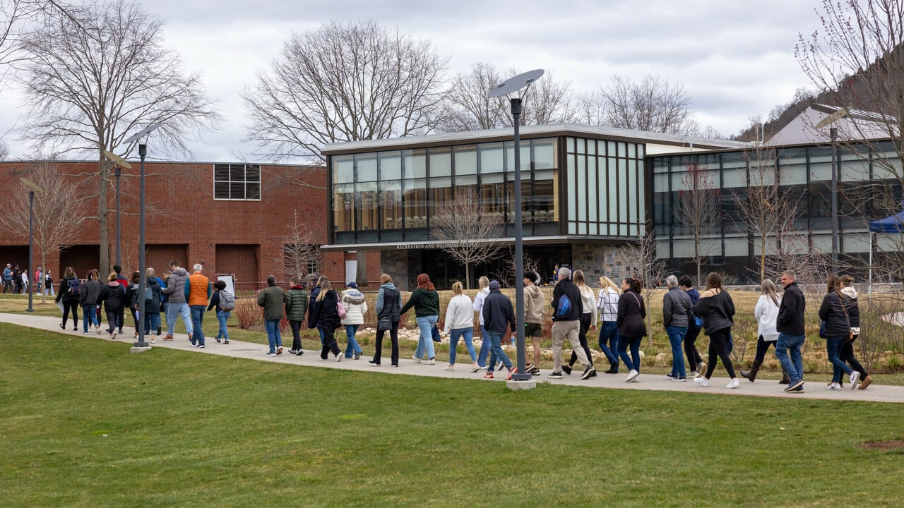 A couple of tour groups walk by the Recreation and Wellness Center