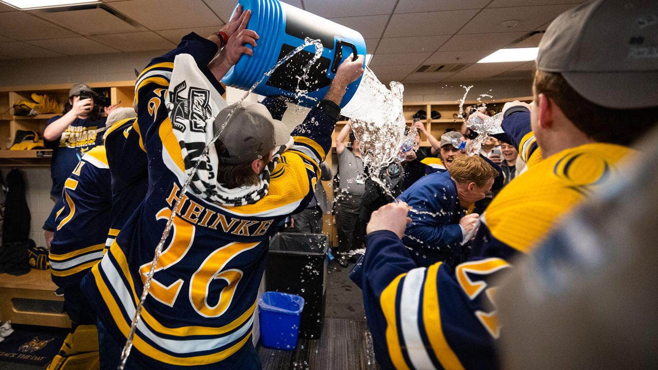 Quinnipiac ice hockey team pours water on the coach to celebrate